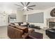 Spacious living room featuring stone fireplace, ceiling fan, and open layout with hardwood flooring and neutral walls at 3051 S Rainbow Ave, Pahrump, NV 89048
