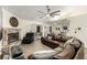 Comfortable living room featuring stone fireplace, ceiling fan, and open layout with hardwood flooring and neutral walls at 3051 S Rainbow Ave, Pahrump, NV 89048