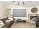 Comfortable living room featuring stone fireplace, ceiling fan, and open layout with hardwood flooring and neutral walls at 3051 S Rainbow Ave, Pahrump, NV 89048