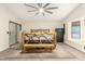 A bright main bedroom featuring rustic wood furnishings, natural light, and a ceiling fan at 3051 S Rainbow Ave, Pahrump, NV 89048