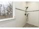 Updated bathroom showcasing a modern tiled shower with decorative accents and window at 3051 S Rainbow Ave, Pahrump, NV 89048