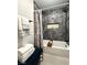 Renovated bathroom showcasing dark marble tiles, a tub, and a stylish shower curtain at 308 Cannes St, Henderson, NV 89015
