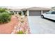 View of front yard with desert landscaping, driveway leading to the garage, and neutral colored exterior at 308 Cannes St, Henderson, NV 89015