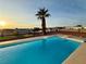 Backyard swimming pool with a sun-drenched deck, lush palm tree, and community views at 308 Cannes St, Henderson, NV 89015