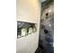 Stylish walk-in shower boasts marble accents, pebble flooring, and decorative recessed planters at 308 Cannes St, Henderson, NV 89015