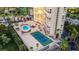 This aerial view features the building with a community pool, tennis courts, seating, and parking at 3111 Bel Air Dr # 7D, Las Vegas, NV 89109