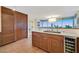 Modern kitchen with custom wood cabinetry, stainless steel wine cooler, hardwood floors, and large window at 3111 Bel Air Dr # 7D, Las Vegas, NV 89109