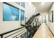 Bright hallway with floating stairs, metal railings, and wood-look tile floors offering modern design at 38 Promenade Isle Ln, Henderson, NV 89011