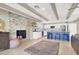 Open-concept living room with exposed beams, stone fireplace, and a kitchen island with barstool seating at 4050 Royalhill Ave, Las Vegas, NV 89121