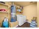 Functional laundry area with a washer, dryer, water heater, and shelving for supplies at 4136 Broadriver Dr, Las Vegas, NV 89108