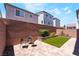 Cozy backyard with a brick perimeter, artificial grass, and outdoor seating area at 7029 Parrot Bay Way, Las Vegas, NV 89118
