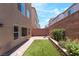 Private backyard featuring pavers, artificial grass, planters, and relaxing shaded seating at 7029 Parrot Bay Way, Las Vegas, NV 89118