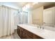 A clean and bright bathroom provides a dual-sink vanity, decorative tile, and combination shower and tub at 7029 Parrot Bay Way, Las Vegas, NV 89118