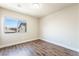 A bright, empty bedroom features a large window and wood-look floors, ready for your personalization at 7029 Parrot Bay Way, Las Vegas, NV 89118