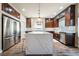 Modern kitchen with stainless steel appliances, an island with a marble countertop, and dark wood cabinets at 7029 Parrot Bay Way, Las Vegas, NV 89118