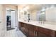 The main bathroom features a dual sink vanity, decorative tile floors, and a separate walk-in closet at 7029 Parrot Bay Way, Las Vegas, NV 89118