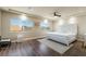 Bright bedroom with hardwood floors, tray ceiling, and an ornate white headboard, offering a relaxing retreat at 7029 Parrot Bay Way, Las Vegas, NV 89118