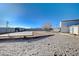 Spacious backyard with sand, red gravel, and a covered patio area at 7477 Ullom Dr, Las Vegas, NV 89139