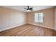 Bright, empty bedroom with ceiling fan, window, and wood-look flooring at 7477 Ullom Dr, Las Vegas, NV 89139