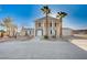 Two-story home featuring a grand entrance, palm trees, and a large, open driveway at 7477 Ullom Dr, Las Vegas, NV 89139