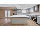 Modern kitchen with stainless steel appliances, a center island, and wood-style floors at 7477 Ullom Dr, Las Vegas, NV 89139