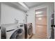 Laundry room with new stainless steel washer and dryer and tile flooring at 7477 Ullom Dr, Las Vegas, NV 89139