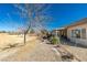 View of home's backyard with desert landscaping overlooking the golf course on a sunny day at 7649 Broadwing Dr, North Las Vegas, NV 89084