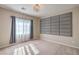 Bedroom with a large window, gray curtains, and neutral paint at 7788 Ebro Valley Ct, Las Vegas, NV 89113