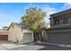 Charming stucco townhouse featuring a tile roof, attached garages, and mature landscaping at 7836 Blesbok Ct, Las Vegas, NV 89149