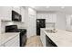 Bright kitchen with white cabinetry, granite countertops, and modern black appliances at 902 Earth Luster Rd, Las Vegas, NV 89178