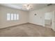 Spacious carpeted bedroom with a ceiling fan, shuttered window, and a doorway to another room at 9517 Alma Ridge Ave, Las Vegas, NV 89178