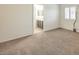 Bright bedroom features neutral carpeting, plantation shutters, and an en suite bathroom at 9517 Alma Ridge Ave, Las Vegas, NV 89178