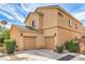 Tan two-story home with two-car garage, easy to maintain landscaping, and a tile roof at 9517 Alma Ridge Ave, Las Vegas, NV 89178
