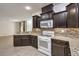 The kitchen has granite countertops, dark cabinets, and stainless steel appliances at 9517 Alma Ridge Ave, Las Vegas, NV 89178