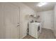 Efficient laundry room featuring a washer, dryer, storage shelf, and access door to the exterior at 9517 Alma Ridge Ave, Las Vegas, NV 89178