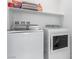 Functional laundry area with modern washer and dryer and convenient overhead shelving at 9714 Harper Edge St, Las Vegas, NV 89143