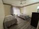 Cozy bedroom with hardwood floors, two beds, a window with curtains, and simple decor at , Las Vegas, NV 89110