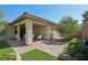 Landscaped backyard with patio area, artificial grass, and lush greenery at 10057 Regency Canyon Way, Las Vegas, NV 89148