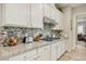Bright kitchen with white cabinets, tile backsplash, stainless steel appliances, and granite countertops at 10057 Regency Canyon Way, Las Vegas, NV 89148