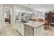 Kitchen with island seating, stainless steel appliances, and open access to the living room and backyard at 10057 Regency Canyon Way, Las Vegas, NV 89148