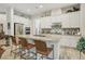 Modern kitchen features a spacious island with seating, stainless steel appliances, and white cabinetry at 10057 Regency Canyon Way, Las Vegas, NV 89148