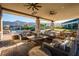 Inviting patio area featuring cozy seating, natural stone elements, ceiling fans, and mountain views at 10057 Regency Canyon Way, Las Vegas, NV 89148