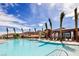 A luxurious community pool is surrounded by palm trees and lounge chairs for resident enjoyment at 10057 Regency Canyon Way, Las Vegas, NV 89148