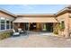 A beautiful covered back patio with outdoor seating, rugs, and a view into the home at 10179 Emerald Sunset Ct, Las Vegas, NV 89148