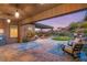 Outdoor back patio with comfortable seating, brick floors, a pergola, and landscaped backyard view at 10179 Emerald Sunset Ct, Las Vegas, NV 89148