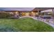 Large backyard with well-maintained lawn, stone patio, outdoor seating, and manicured landscaping at 10179 Emerald Sunset Ct, Las Vegas, NV 89148