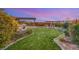 Lush green backyard with manicured lawn, stone pathway, and mature trees providing a serene outdoor retreat at 10179 Emerald Sunset Ct, Las Vegas, NV 89148