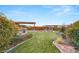Gorgeous backyard featuring lush lawn, landscaping, covered patios, and an outdoor entertaining area at 10179 Emerald Sunset Ct, Las Vegas, NV 89148