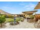 Expansive backyard with mature landscaping, a covered patio, hot tub, stone walkway, and mountain views at 10179 Emerald Sunset Ct, Las Vegas, NV 89148