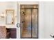 Close up of glass shower, seat, tile, and vanity in the beautiful primary bathroom at 10179 Emerald Sunset Ct, Las Vegas, NV 89148